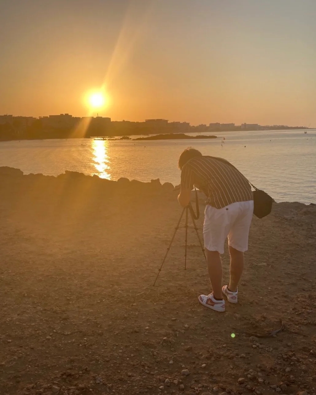 Adam med kamera vid solnedgång